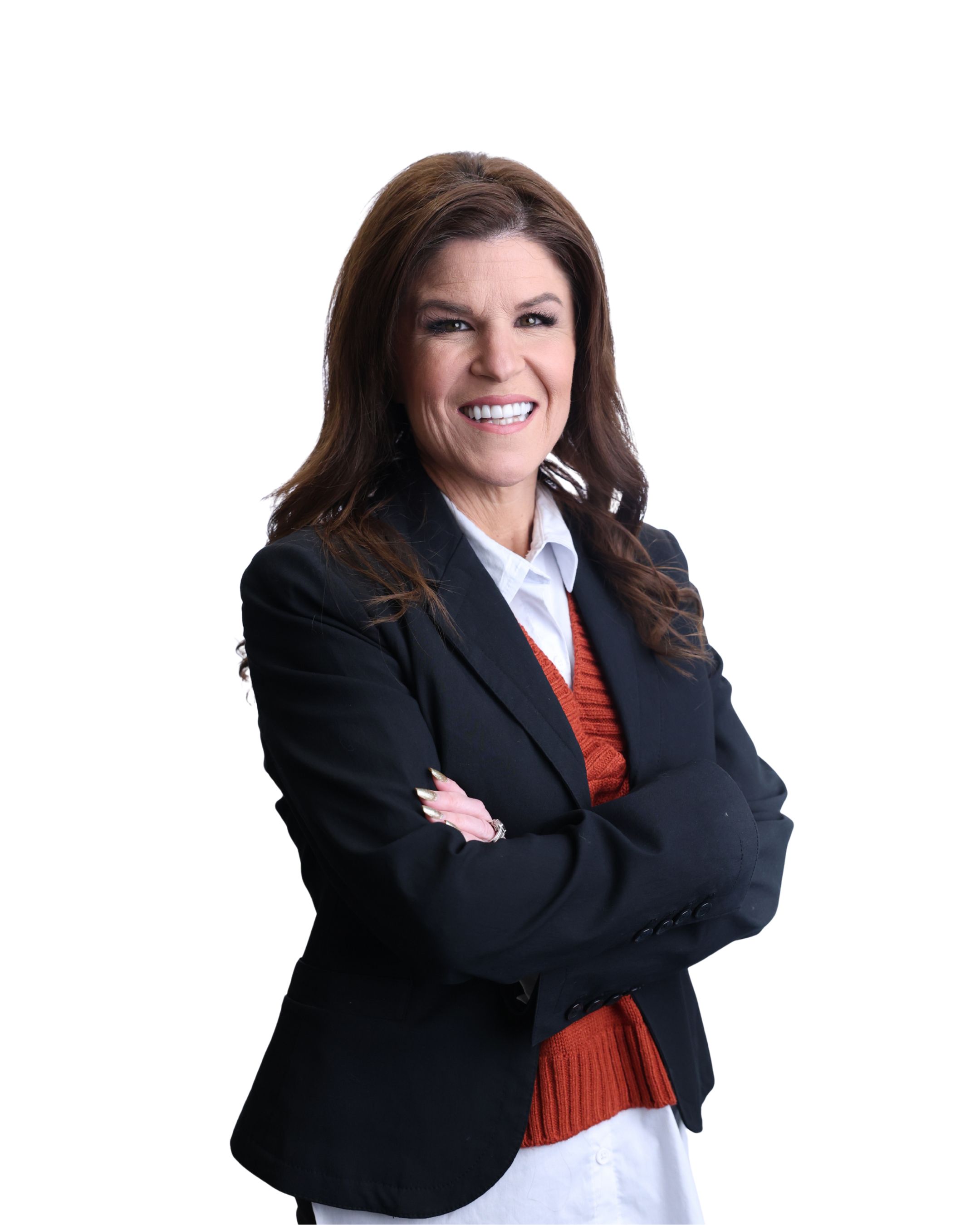 Smiling woman with long brown hair stands confidently, arms crossed. She wears a black blazer, orange sweater, and white shirt. Bright, white background.
