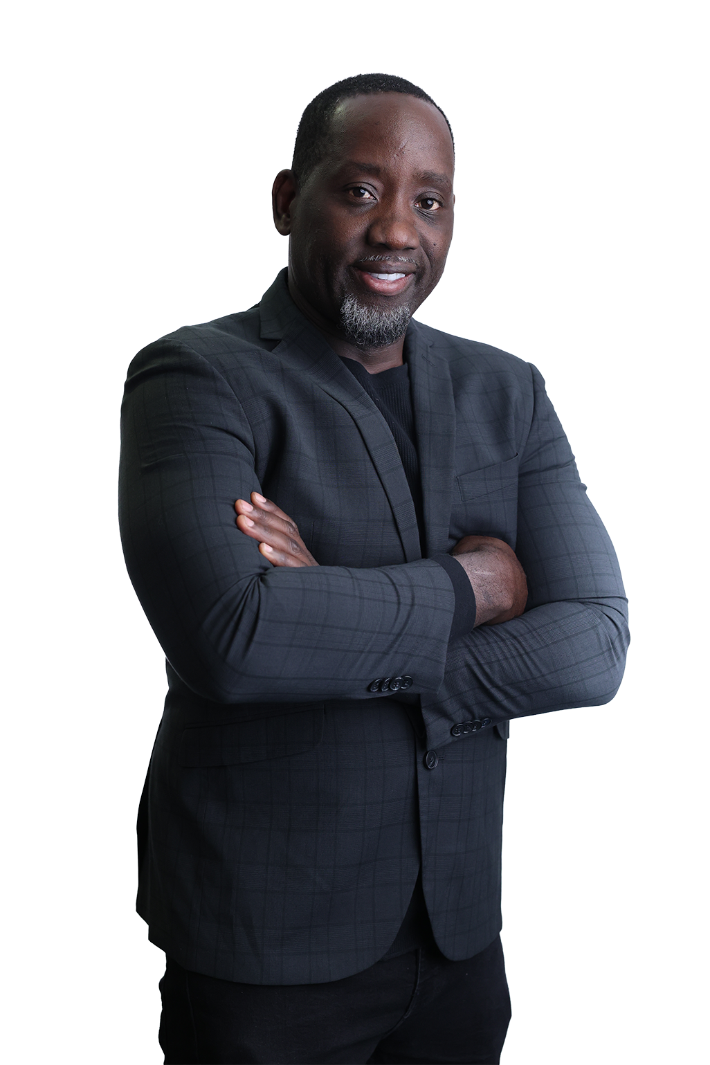 A man in a dark suit with a checkered pattern stands confidently with arms crossed. He smiles slightly against a black background, conveying professionalism.