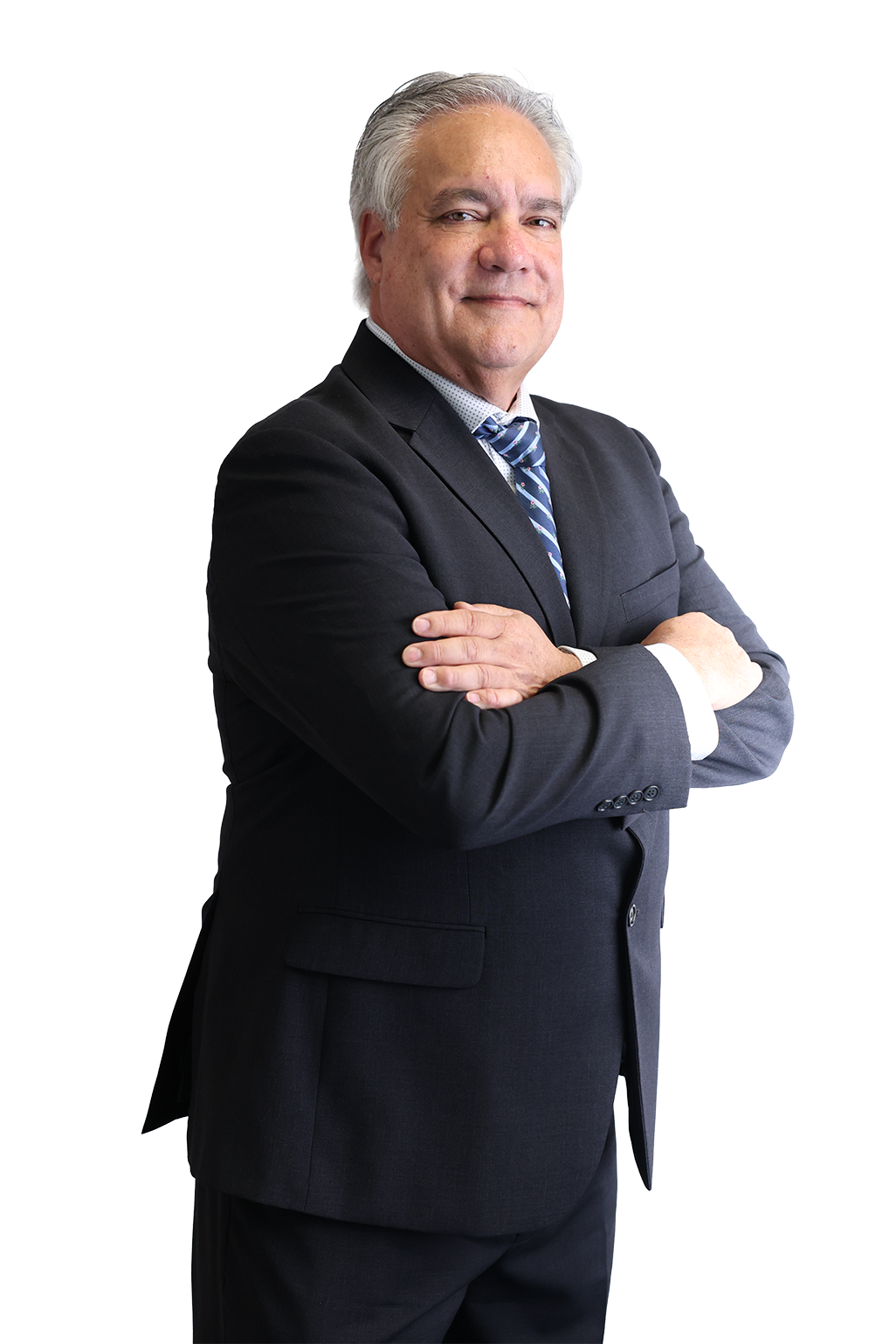 Elderly man in a suit with arms crossed, smiling confidently against a black background. He wears a striped tie, conveying professionalism and authority.