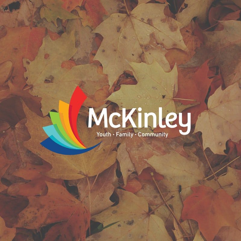 Logo of "McKinley" with the slogan "Faith. Family. Community." over autumn leaves. The colorful logo contrasts with the warm, earthy background.