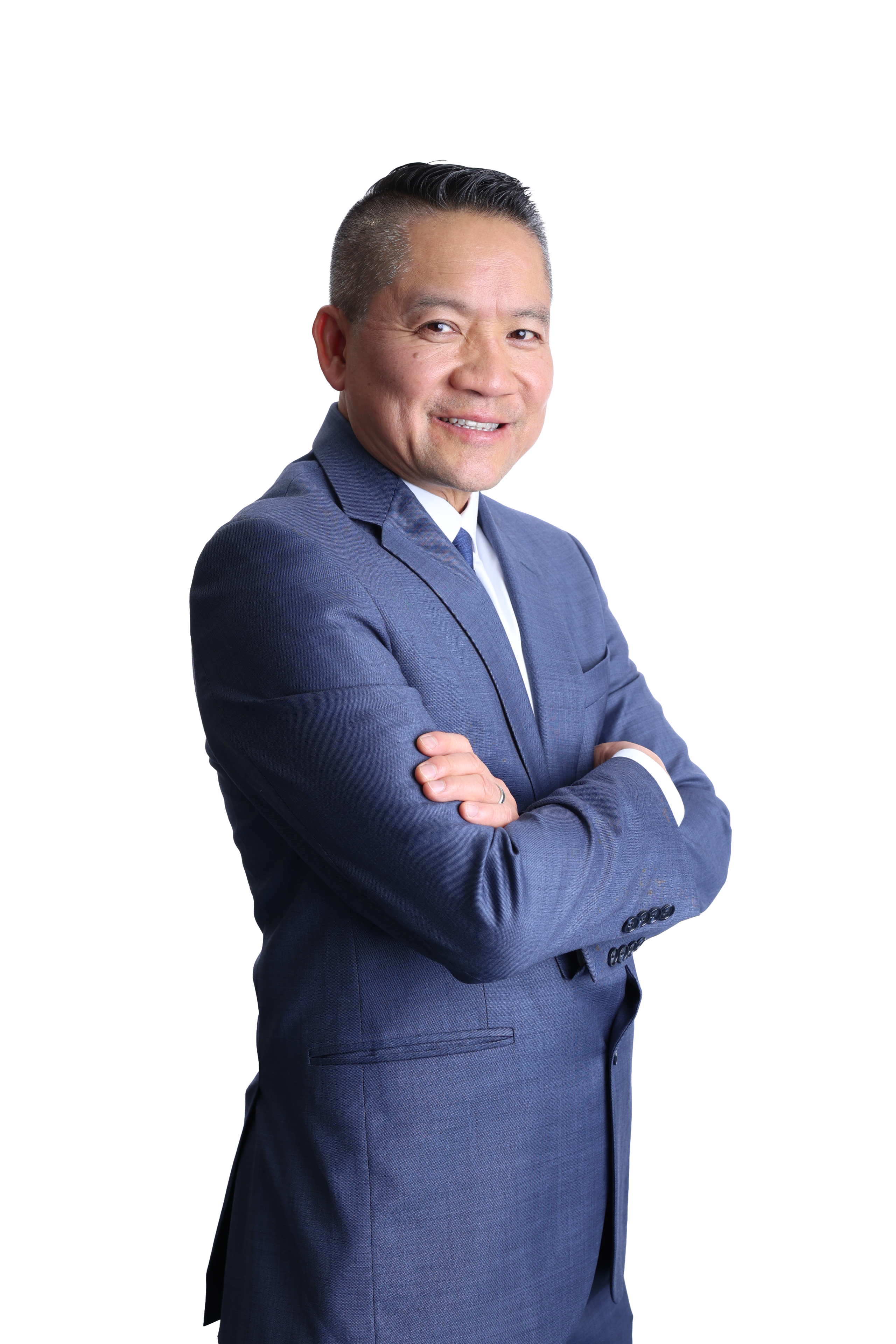 A person in a blue suit and white shirt stands confidently with crossed arms against a black background, conveying professionalism and approachability.